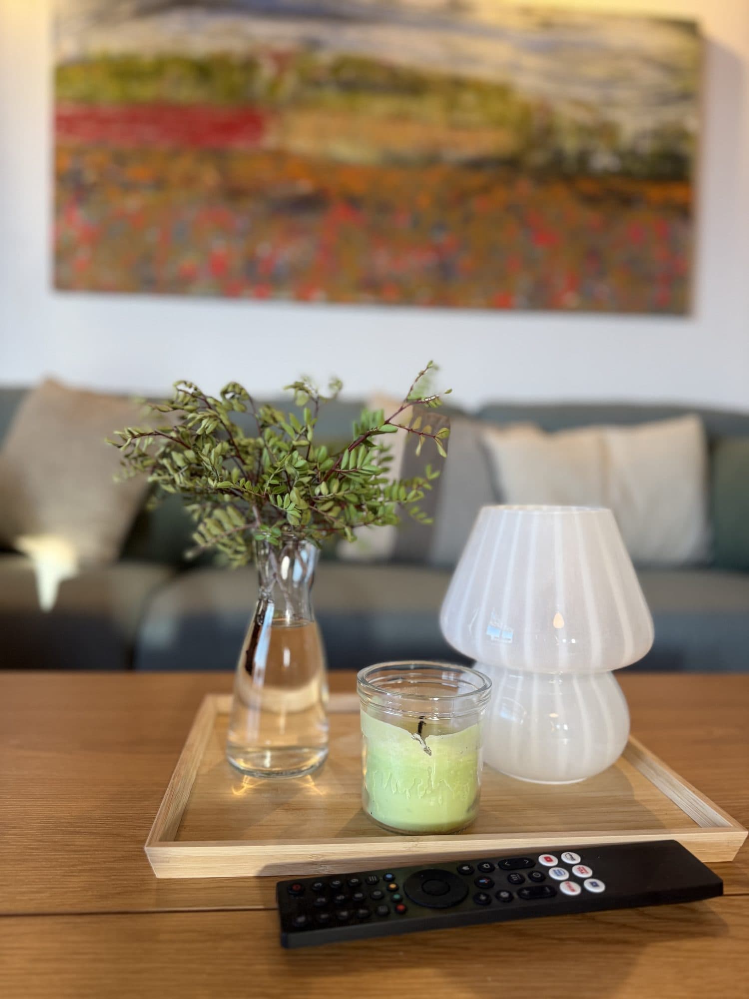 Living-room details — fresh greenery, candlelight and art